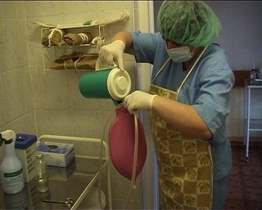 В кружку Эсмарха наливают необходимое количество жидкости