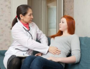 врач осматривает вздутый живот